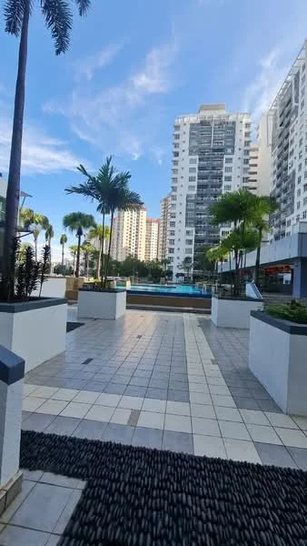 Exterior type: high-rise condominium; features: swimming pool, pool deck with loungers, manicured landscaping, palm trees, tiled walkway, modern facade, surrounded by high-rise buildings, outdoor seating area; style: modern.