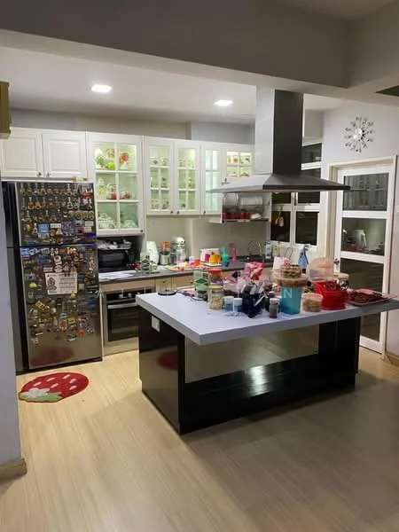 Kitchen features: stainless-steel fridge with magnets, white shaker cabinets, glass-front upper cabinets, black kitchen island with seating, marble countertop, built-in oven, microwave, kettle, toaster, various kitchen utensils, decorative items on shelves, wooden flooring, recessed downlights; style: modern.