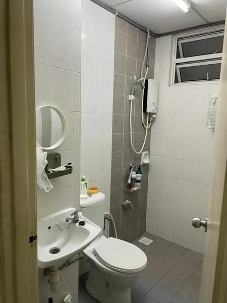 Bathroom features: white tiled walls, grey tiled flooring, single-sink vanity with mirror, chrome basin mixer faucet, one-piece toilet, shower with handheld showerhead, wall-mounted water heater, window for natural light, towel rack, soap dispenser, toilet paper holder; style: modern.