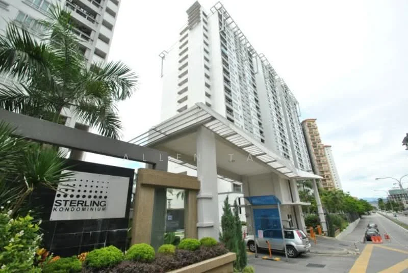 Exterior type: high-rise condominium; features: modern facade with glass and concrete, main entrance with awning, landscaped garden with shrubs, paved driveway, security guardhouse at entrance, visible parking area, surrounded by urban environment; style: modern.