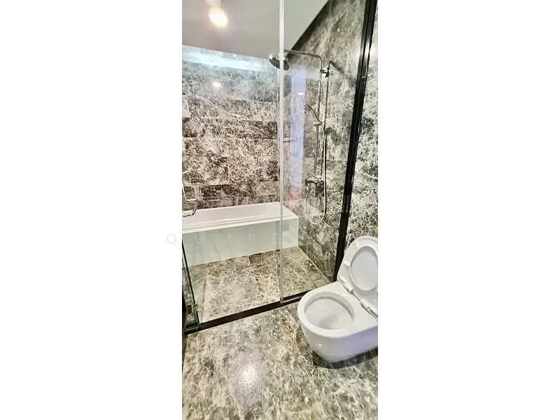 Bathroom features: bathtub, glass shower enclosure, marble wall cladding, marble flooring, one-piece toilet, chrome shower fixtures, recessed lighting, black framed glass door; style: modern.