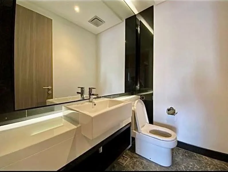Bathroom features: white wall tiles, black accent wall, floating vanity with sink, chrome basin mixer faucet, large mirror, one-piece toilet, toilet paper holder, recessed lighting, marble flooring; style: modern.