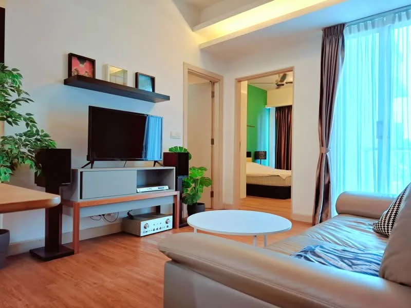 Living features: leather sofa, round coffee table, wall-mounted TV, TV console, wooden flooring, large windows with sheer curtains, decorative plants, shelf with framed artwork, recessed ceiling lights; style: modern. Room features: doorway leading to another room, green accent wall, ceiling fan.