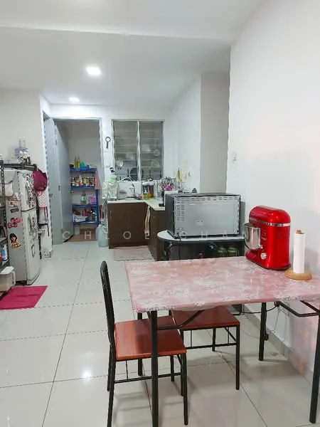 Kitchen features: white painted walls, glossy tile flooring, refrigerator, microwave, kitchen table with pink floral design, two black chairs, kitchen cabinets, sink, countertop, kettle, decorative items on shelves; style: modern.