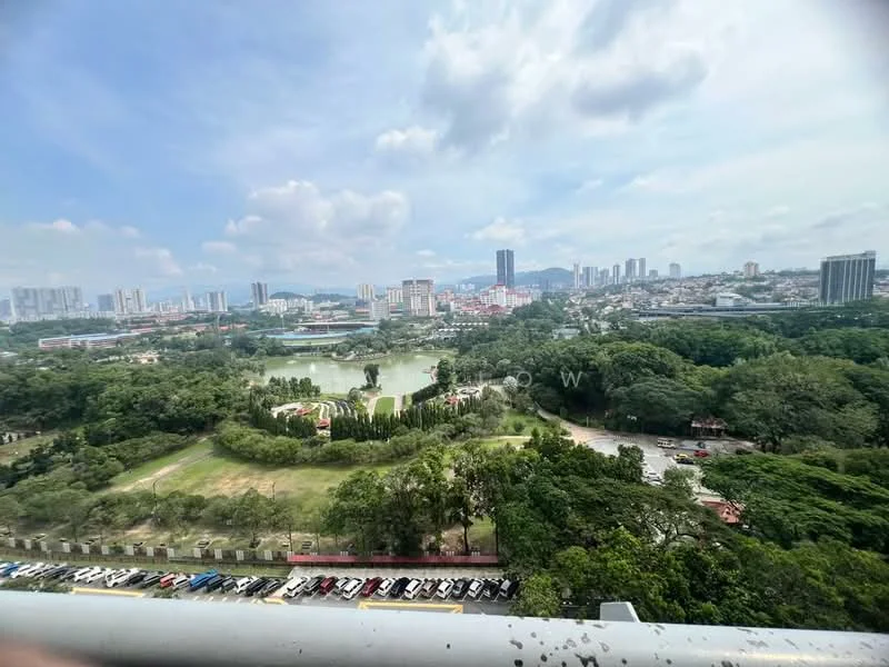 Exterior type: high-rise condominium; features: city skyline view, lush greenery, park area, water body, surrounding urban development, open-air parking lot; style: modern.