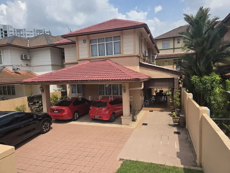 Exterior type: detached bungalow; features: red tiled roof, cream painted facade, two-storey structure, car porch with awning, paved driveway, manicured lawn, surrounded by greenery, two parked red cars, visible windows on upper floor, landscaped garden area; style: modern.