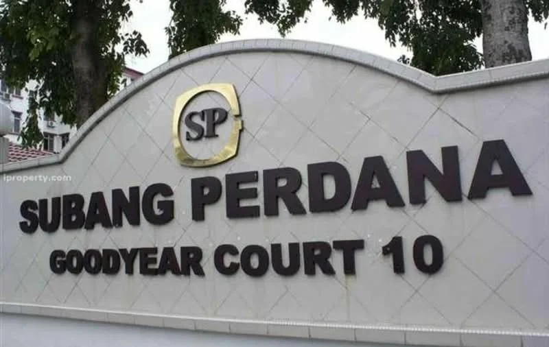 Exterior features: signage with the name 'Subang Perdana Goodyear Court 10', decorative arch design, landscaping with trees, stone or concrete base, large letters for visibility; style: modern.