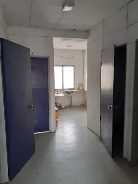 Room features: white painted walls, concrete flooring, two blue doors, window with white frame, overhead lighting, work surface or countertop, neutral color scheme; style: minimalist.