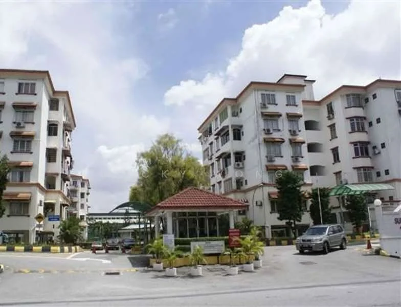 Exterior type: low-rise apartment block; features: white painted facade, red tiled roof, multiple balconies, landscaped entrance with plants, guard house at entrance, paved driveway, parking spaces visible, surrounded by mature trees; style: modern.