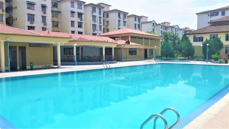 Exterior type: swimming pool deck; features: large swimming pool, surrounding deck area, multiple residential buildings in background, landscaped greenery, sun loungers, poolside lighting, covered seating area, tile flooring around pool, sliding doors to building, palm trees; style: modern.