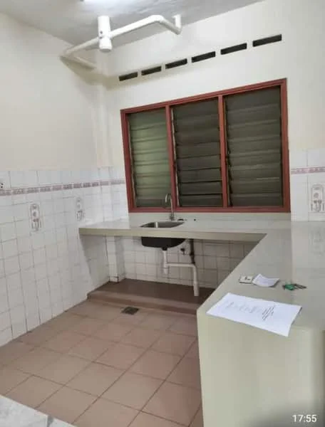 Kitchen features: single-bowl stainless-steel sink, chrome pull-down faucet, white tiled walls, light beige tiled flooring, countertop with integrated sink, window with horizontal slats, kitchen cabinetry below countertop, exposed plumbing, paperwork on countertop.