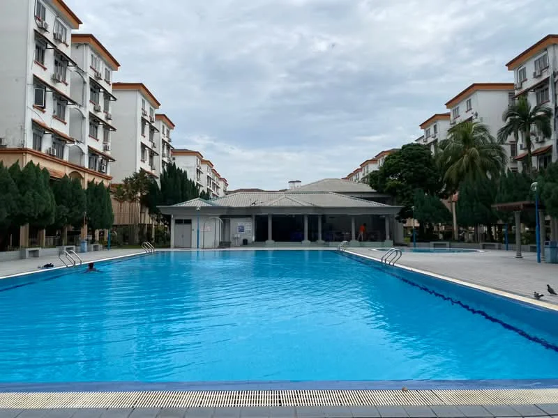 Exterior type: low-rise apartment block; features: swimming pool, pool deck with loungers, landscaped garden with trees, covered pavilion, surrounding residential buildings, manicured lawn; style: modern.