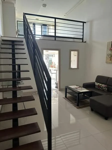 Living features: open-plan layout, white painted walls, polished ceramic tile flooring, sofa in dark grey fabric, coffee table, area rug, decorative wall art, staircase with wooden treads and metal railing, large windows for natural light, ceiling light fixture; style: modern. Room features: white painted walls, polished ceramic tile flooring, doorway leading to kitchen, natural light from windows.