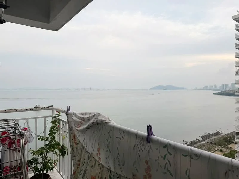 Balcony features: white railing, sea view, decorative fabric hanging, potted plant, concrete flooring; view: sea.