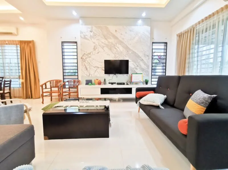 Living features: grey fabric sofa with orange and black cushions, black coffee table with glass top, white TV console, wall-mounted flat-screen TV, marble feature wall, recessed ceiling lights, cream painted walls, white tiled flooring, large windows with sheer curtains, wooden chairs, decorative plants, colorful decorative items on console; style: modern.