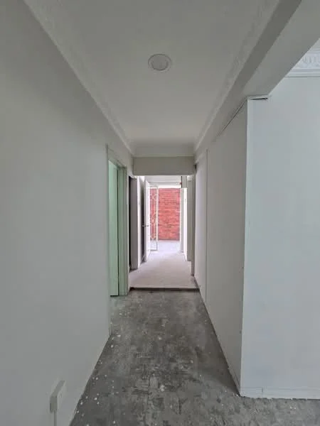 Room features: white painted walls, grey concrete flooring, crown moulding, doorway leading to outdoor space, natural light from windows, unfurnished space.