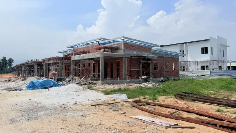 Exterior features: brick facade, concrete structure, scaffolding visible, partially constructed roof, blue roof trusses, surrounding construction site, grassy area, sand and gravel on ground; style: modern.