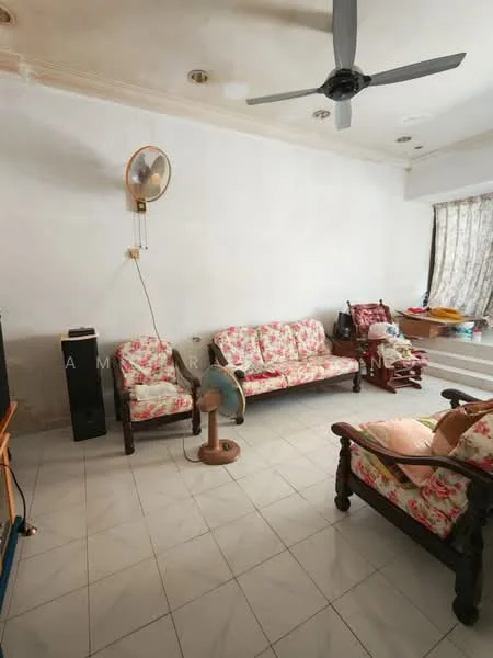 Living features: floral-patterned fabric sofa, 2-seater sofa, 3-seater sofa, ceiling fan, tiled flooring, white painted walls, window with sheer curtains, wooden furniture, TV console, standing fan.