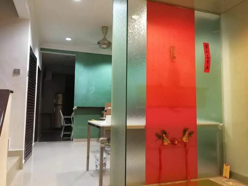 Room features: green painted walls, glass partition, white tiled flooring, ceiling fan, table with chairs, decorative wall hanging, red decorative elements, recessed lighting; style: modern.