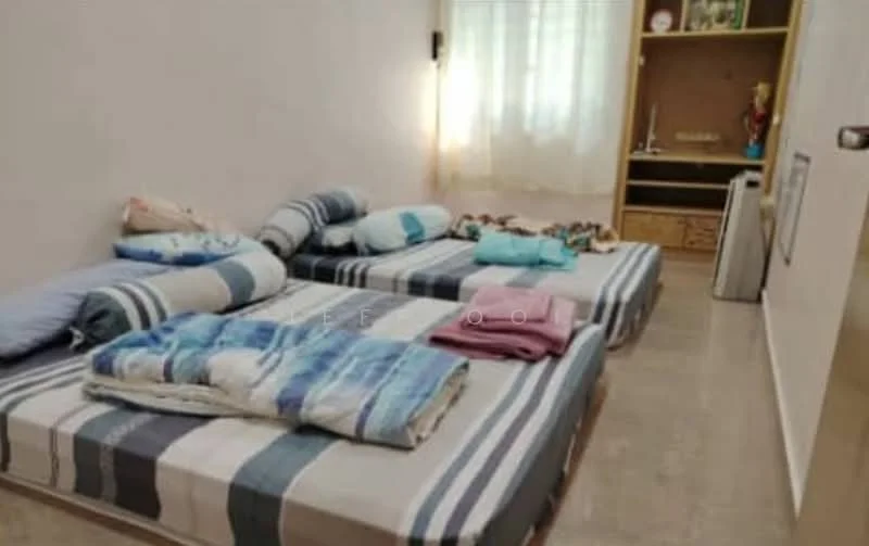 Bedroom features: two single beds with striped bedding, light-colored walls, large window with sheer curtains, wooden shelving unit, decorative items on shelves, laminate flooring, various cushions and blankets, soft lighting.