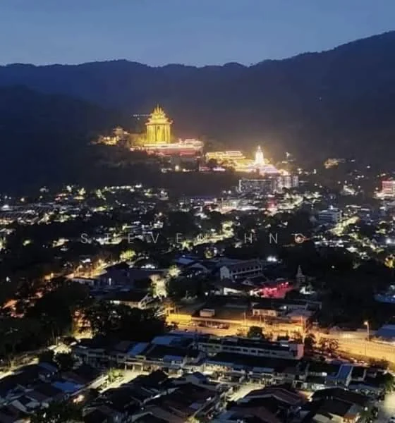 Exterior features: night view of city skyline, illuminated temple on hill, surrounding mountains, urban landscape with street lights, dense residential area, scattered commercial buildings; style: contemporary.