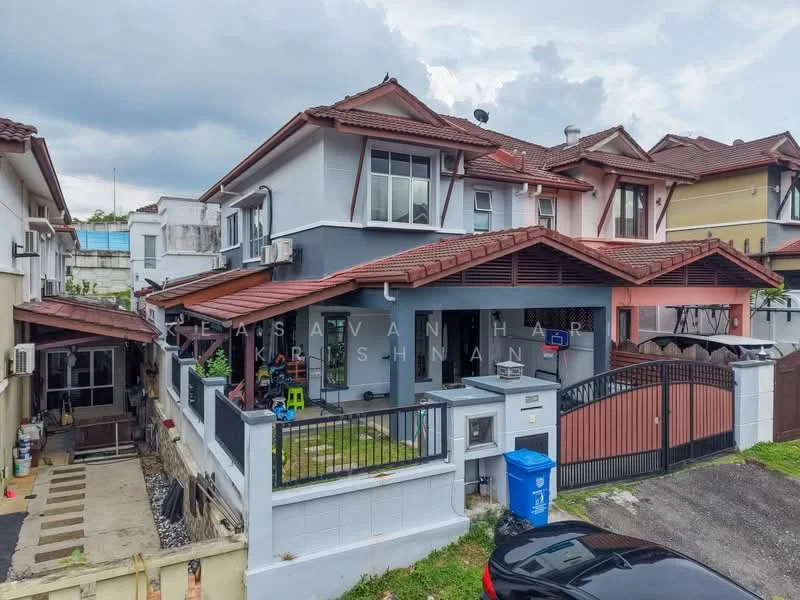 Exterior type: semi-detached house; features: red tiled roof, white painted facade, balcony with railing, front porch with gate, manicured lawn, driveway with interlocking pavers, visible air conditioning units, fenced perimeter, two-storey structure, garage space, outdoor seating area; style: modern.
