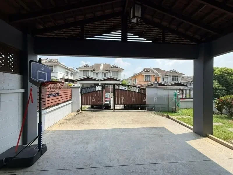 Exterior type: linked terrace house; features: covered car porch, basketball hoop, concrete flooring, manicured lawn, fenced perimeter, gate entrance, two-storey houses in background, landscaped garden, paved driveway; style: modern.