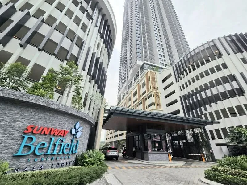 Exterior type: high-rise condominium; features: glass curtain wall, stone cladding, double-volume main lobby, guard house at entrance, gated entry, landscaped entrance with greenery, parking area, surrounded by mature greenery; style: modern.