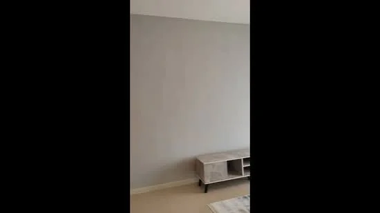 Room features: light grey painted walls, beige carpet flooring, wooden TV console, minimalist design; style: modern.