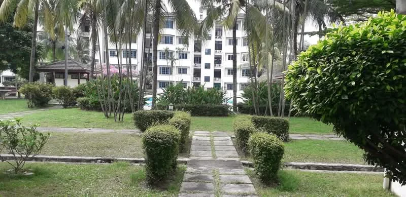Exterior type: low-rise apartment block; features: manicured lawn, paved walkway, hedge landscaping, mature palm trees, swimming pool visible in background, flowering plants, garden area, outdoor seating pavilion; style: tropical-modern.