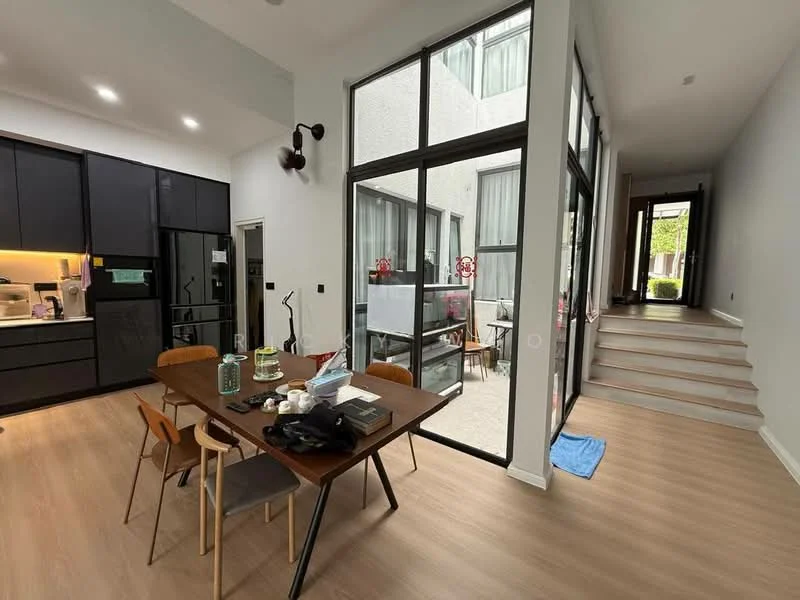 Living features: large floor-to-ceiling windows, black cabinetry, light wood flooring, dining table with four chairs, recessed ceiling lights, open layout, decorative plants, staircase leading to upper level; style: modern; view: garden.