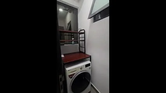 Laundry features: front-load washing machine, wooden shelf unit, white walls, tile flooring, window for natural light, metal ladder shelf, small countertop space; style: modern.