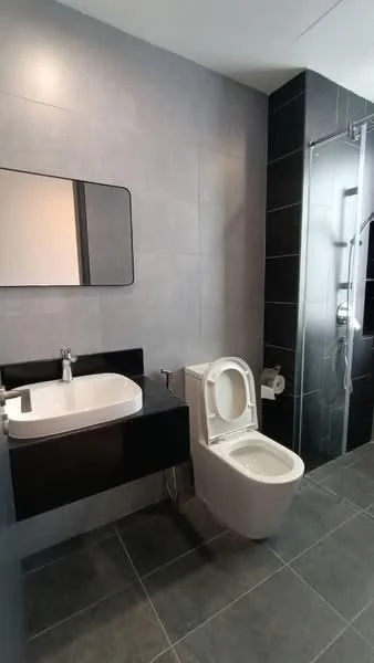 Bathroom features: single-sink vanity with black cabinet, white countertop, framed mirror, one-piece toilet, walk-in shower with glass enclosure, rain shower head, handheld shower, grey tile flooring, grey wall tiles, chrome faucet, toilet paper holder, towel rack; style: modern.