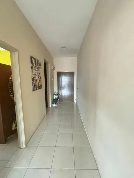 Hallway features: cream painted walls, white tiled flooring, doorway leading to another room, doorway leading to the main entrance, decorative artwork on wall, light switch, light fixture, shoe rack.