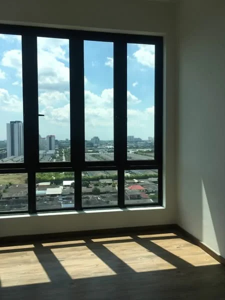 Room features: large floor-to-ceiling windows, black window frames, wooden flooring, city skyline view, natural light, neutral wall color; style: modern; view: city.