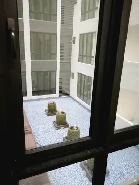 Room features: floor-to-ceiling windows, view of courtyard, paved courtyard with decorative stones, water feature with three stone fountains, surrounding building walls, glass railing, modern architectural design; style: modern; view: courtyard.