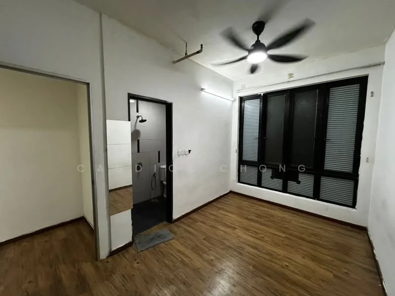 Room features: wooden flooring, white painted walls, ceiling fan, large windows with black frames, grey tiled bathroom area visible, doorway leading to another room, light fixture on ceiling; style: modern.