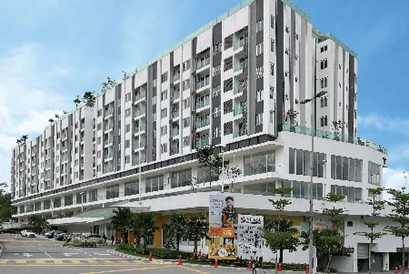 Exterior type: mid-rise condominium; features: white painted facade, glass curtain wall, recessed balconies, landscaped greenery at base, multiple storeys, parking area visible, signage at ground level, paved driveway, surrounded by trees; style: modern.