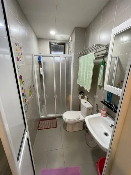 Bathroom features: grey tiled walls, light grey tiled flooring, glass shower enclosure, chrome shower head, toilet, single-sink vanity with white cabinet, mirror with white frame, towel rack, green towel, pink bath mat, decorative wall stickers; style: modern.