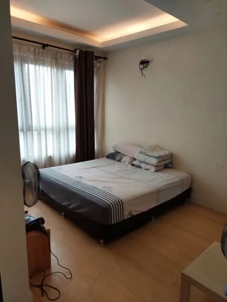 Bedroom features: queen-size bed, light-colored bedding, wooden flooring, floor-to-ceiling windows, sheer curtains, dark brown curtains, wall-mounted light fixture, side table, table fan.