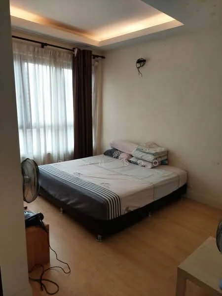 Bedroom features: queen-size bed, light-colored bedding, wooden flooring, floor-to-ceiling windows, sheer curtains, dark brown curtains, wall-mounted light fixture, nightstand, table fan, decorative wall paneling, recessed ceiling lighting; style: modern.