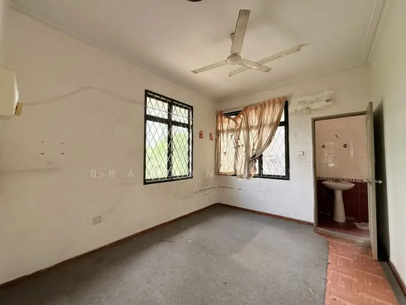 Room features: light grey carpet flooring, white painted walls, ceiling fan, two windows with security grills, curtains, wall-mounted air conditioning unit, door leading to bathroom, visible plumbing fixtures in bathroom, unpainted wall with marks, tile flooring in bathroom area; view: garden.