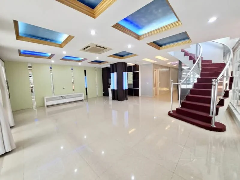 Living features: glossy marble flooring, white walls, tray ceiling with blue lighting, gold crown moulding, recessed downlights, staircase with red carpet, large windows, mirrored wall, built-in cabinetry, open layout; style: modern.