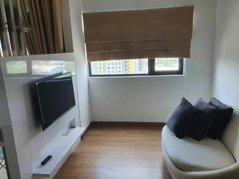 Living features: floor-to-ceiling window, window treatment with roller blinds, light wood flooring, white wall, built-in TV console, wall-mounted TV, curved sofa, decorative cushions; style: modern; view: city.