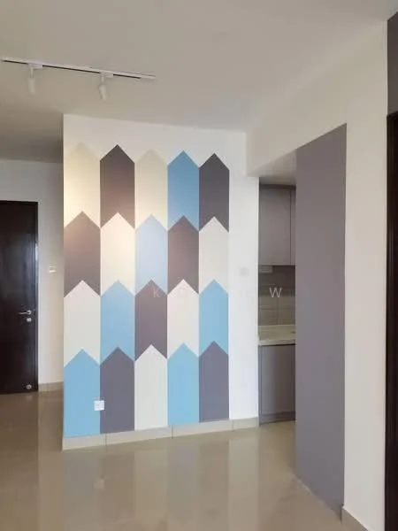 Room features: geometric accent wall with blue, grey, and beige colors, cream tiled flooring, recessed ceiling lights, kitchen area visible in background with grey cabinetry, neutral wall color, door leading to another room, open layout, no visible furniture; style: modern.