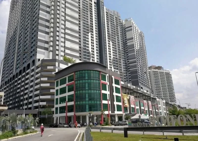 Exterior type: high-rise condominium; features: glass curtain wall, white painted facade, red accent panels, multiple storeys, parking deck, landscaped entrance, signage at entrance, surrounded by urban environment; style: modern.