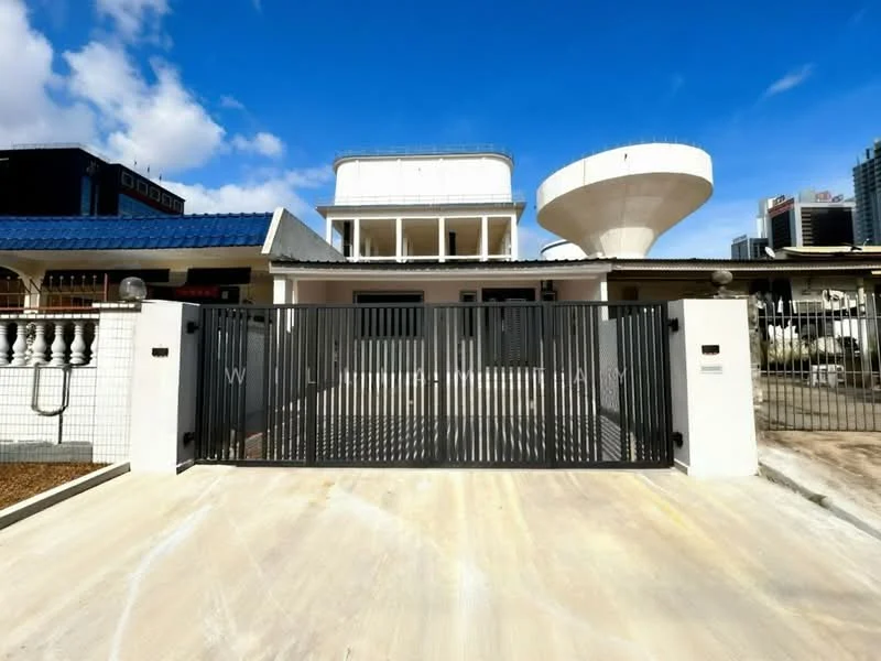 Exterior type: detached bungalow; features: white painted facade, flat roof, front gate with metal grille, concrete driveway, water tank on roof, manicured lawn, surrounded by urban buildings, outdoor lighting fixtures, paved walkway, fenced perimeter; style: modern.