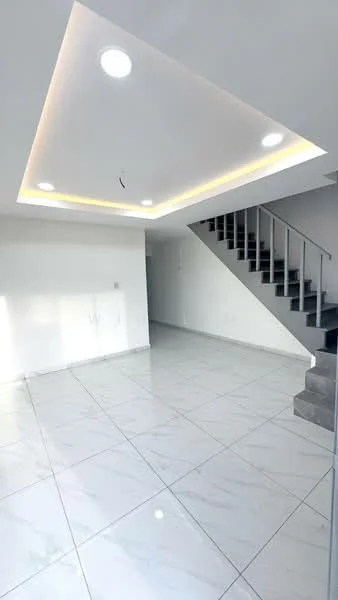 Room features: white painted walls, marble tile flooring, tray ceiling with recessed lighting, staircase with metal railing, large windows for natural light, open layout, no visible furniture, neutral color scheme; style: modern.