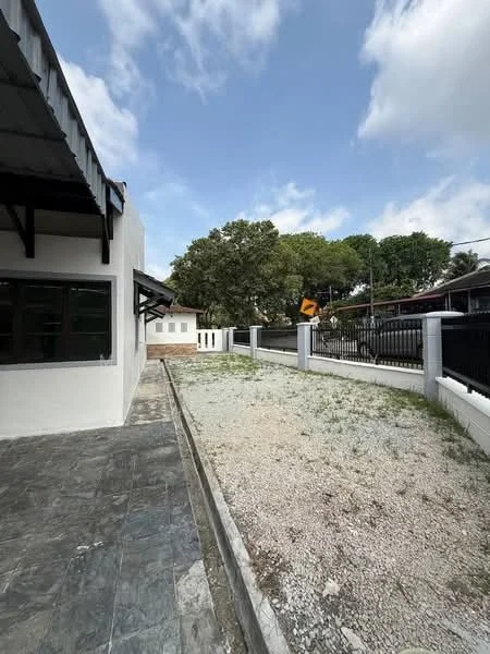 Exterior type: detached bungalow; features: white painted facade, flat roof, stone-paved walkway, manicured lawn, mature trees, fenced perimeter, gravel landscaping, outdoor space, driveway, side yard; style: modern.