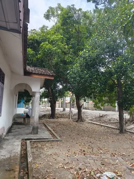Exterior features: single-storey building, concrete facade, gabled roof, manicured lawn, mature trees, stone-paved walkway, gravel area, surrounded by greenery; style: traditional.